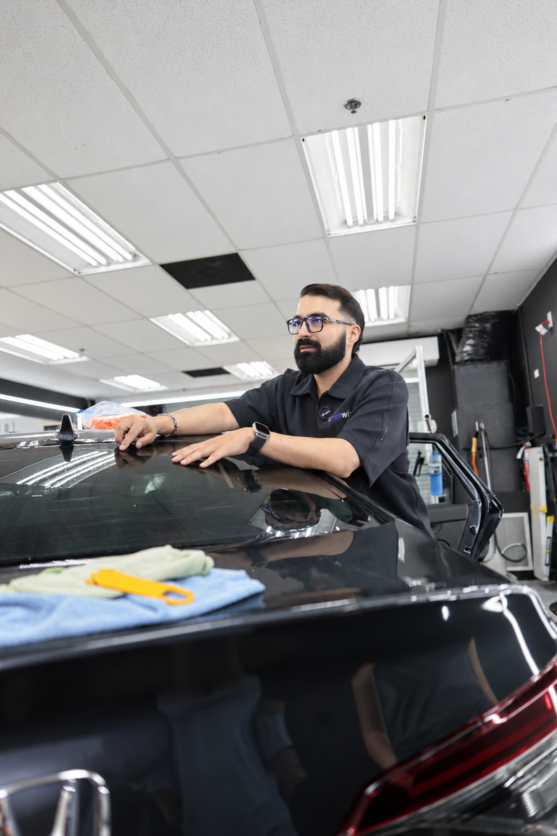 Marco Cazorla demonstrating window film technique on a car's rear glass