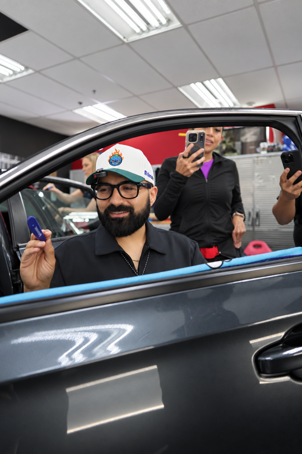 Marco Cazorla smiling while demonstrating window tint work at a car door